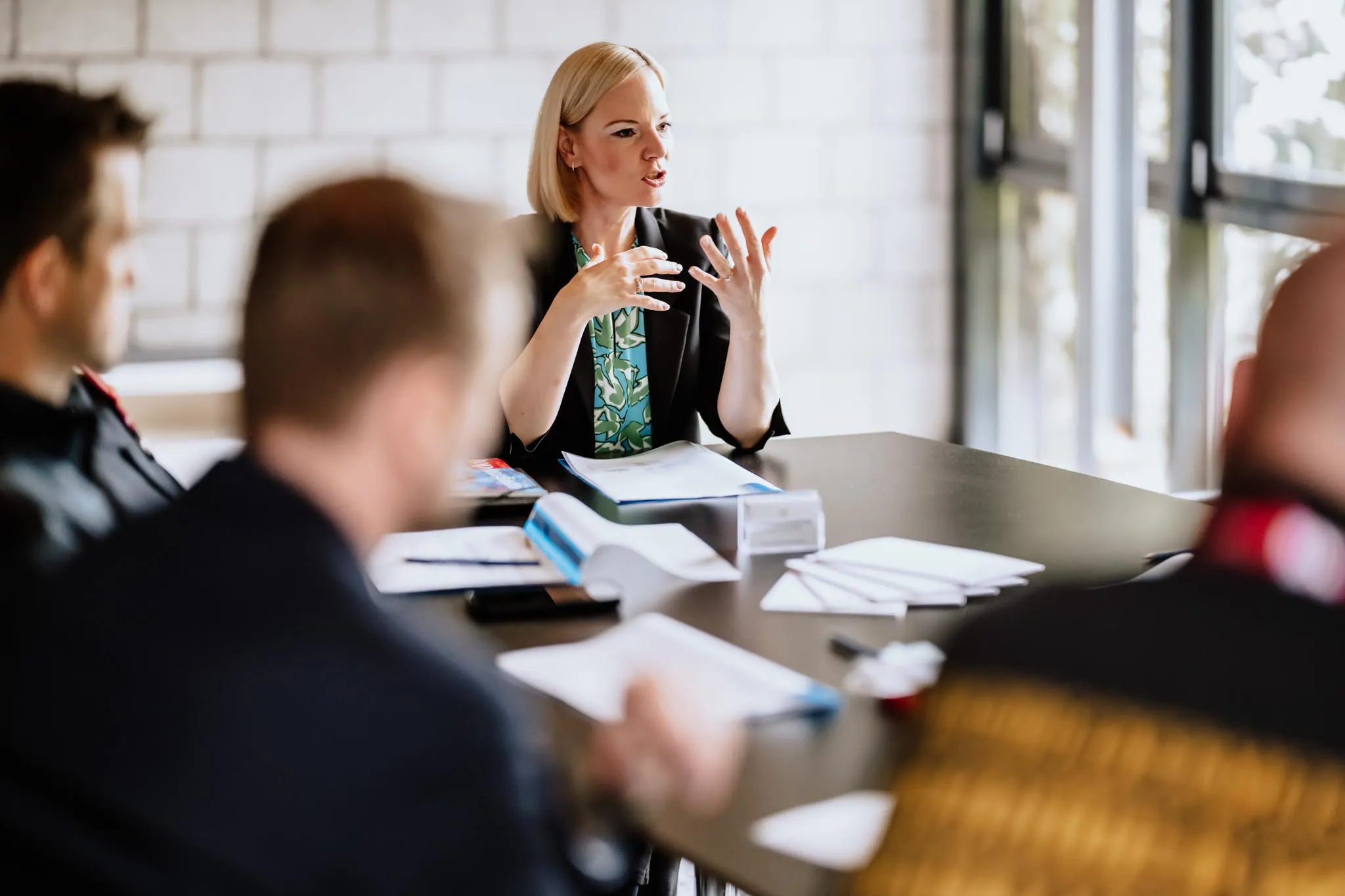 Moderierte Arbeitsrunde mit Teilnehmenden an einem Seminartisch